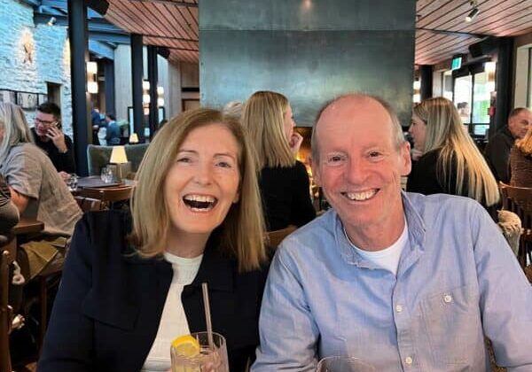 Robyn And Husband sitting side by side laughing